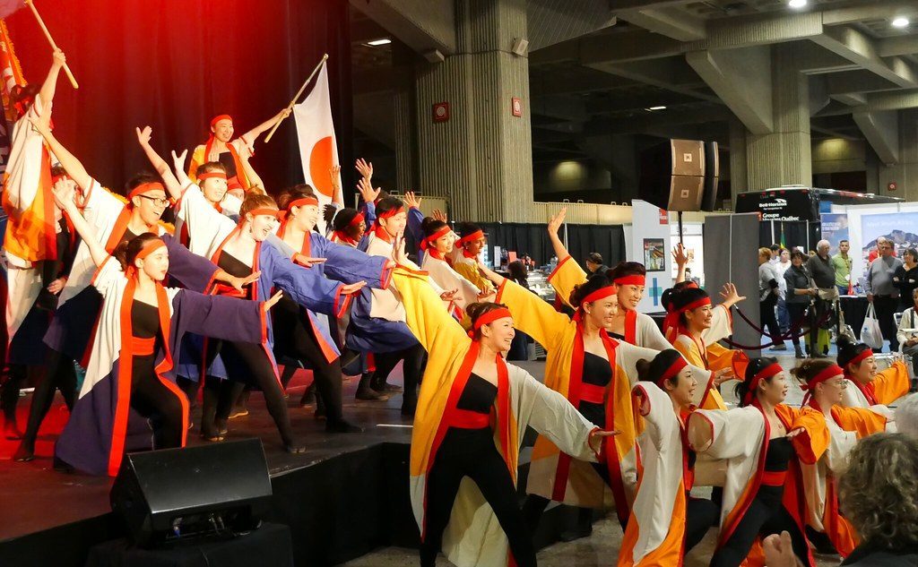 A dance troupe performing on stage in bright costume