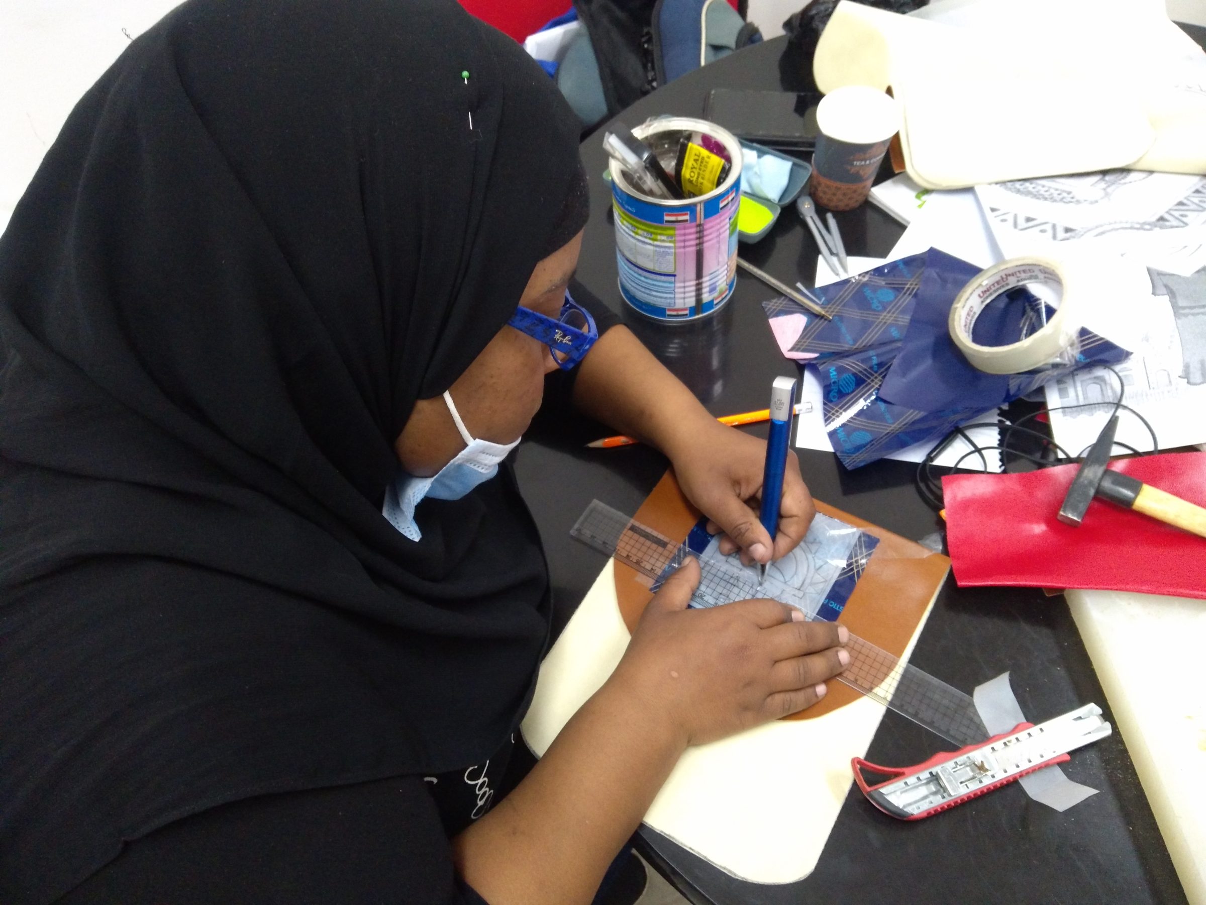 A participant working on a craft piece by hand