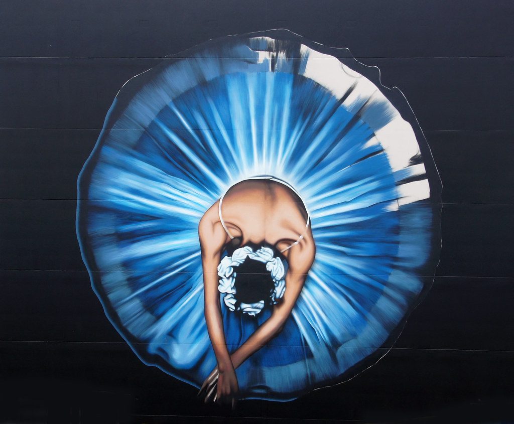 A large circular mural painted on a street wall